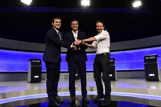 Leader of Spanish Socialist Party (PSOE) Pedro Sanchez (C), leader of left wing party Podemos Pablo Iglesias (R) and center-right party Ciudadanos leader Albert Rivera (L) pose hands in hands before a debate organized by Spanish newspaper El Pais at the F4 Studios at Boadilla del Monte, near Madrid ahead of the Spanish general elections held on December 20, on November 30, 2015. AFP PHOTO/ JAVIER SORIANO / AFP / JAVIER SORIANO (Photo credit should read JAVIER SORIANO/AFP/Getty Images)