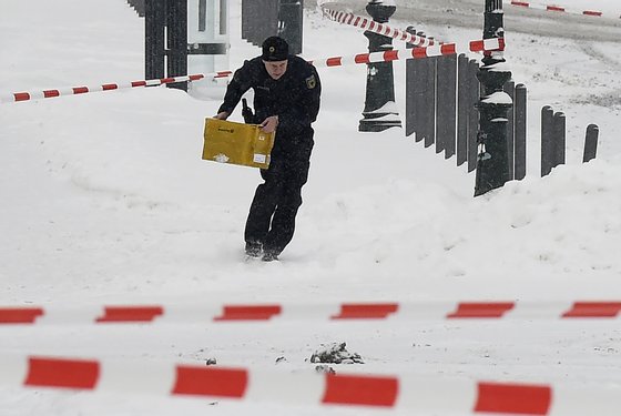 A policeman carries a post box through a blocked area in front of the Chancellery in Berlin on January 6, 2016, as a suspicious mail was found. The German cabinet is to hold it's weekly meeting at the Chancellery. / AFP / TOBIAS SCHWARZ (Photo credit should read TOBIAS SCHWARZ/AFP/Getty Images)