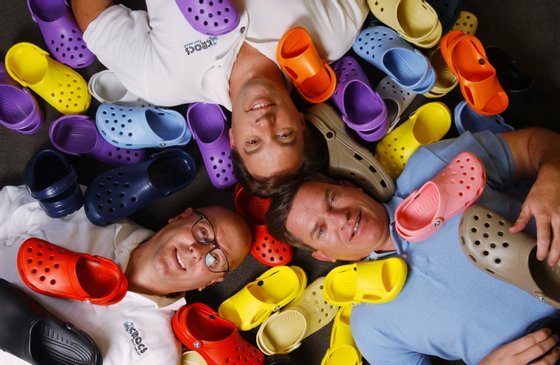 NIWOT, COLORADO, JUNE 23, 2004--The founders of Crocs footwear pose with a variety of their products at their Niwot offices. Clockwise from left (starting with the man in glasses), Scott Seamans , director of product development; Lyndon (Du