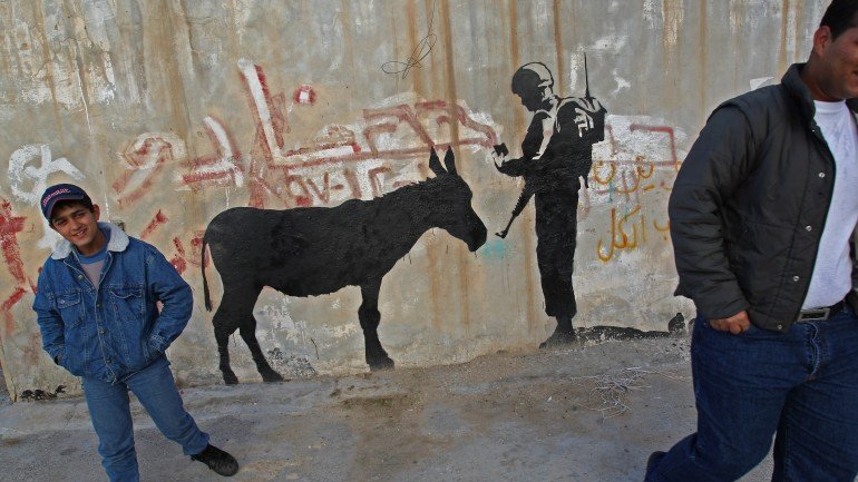Imagem do mural da autoria de Banksy no muro que separa Israel da Faixa de Gaza. Chama-se &quot;Donkey Documents&quot; e foi pintado em 2007