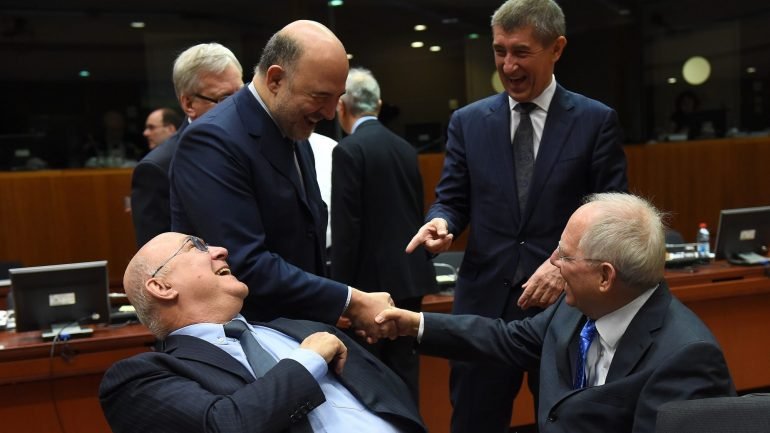Michel Sapin, ministro das Finanças francês, sentado lado do seu homólogo alemão, Wolfgang Schauble na reunião do Ecofin de janeiro. O alemão está a apertar a mão do comissário Moscovici e Andrej Babis, ministro das Finanças da República Checa, aponta para Sapin
