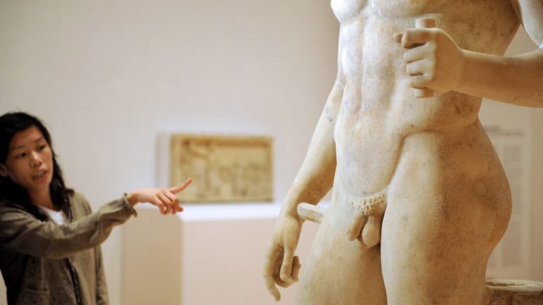 Uma mulher aponta para a estátua de &quot;Borghese Ares&quot;, o deus grego da guerra