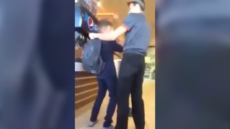 O vídeo mostra o funcionário a obrigar o jovem a utilizar uma esfregona para limpar o chão