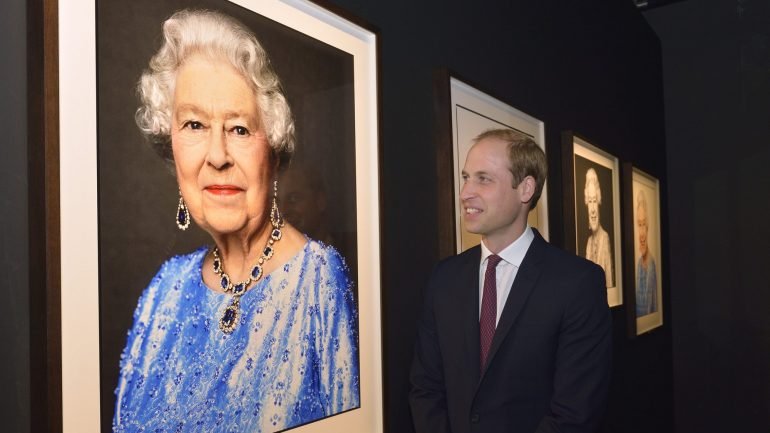 Principe William, segundo na linha de sucessão ao trono britânico, surge ao lado da fotografia da avó, a Rainha Isabel II, onde esta ostenta o colar de Safiras