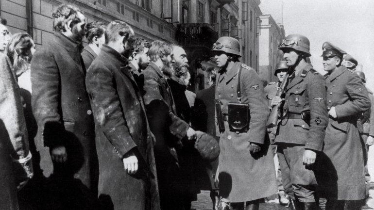 Oficiais nazis reúnem judeus no gueto de Varsóvia, em 1943. Muitos deles foram enviados para campos como o de Treblinka