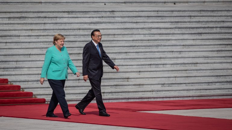 Angela Merkel, à esquerda, e o primeiro-ministro chinês Li Keqiang, à direita, na cerimónia de abertura deste encontro