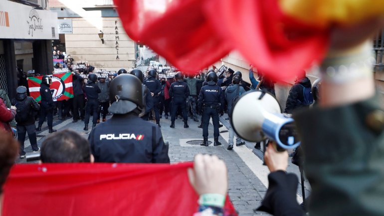 Antifascistas (em segundo plano) confrontam cerca de 100 partidários do Vox segurando bandeiras espanholas em Pamplona, ​​Espanha, 12 de janeiro de 2020