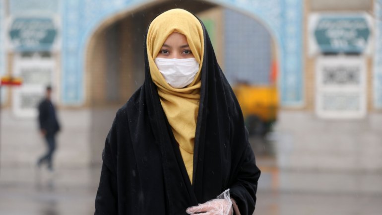 Mulher de máscara em Qom, a cidade iraniana onde teve início o surto