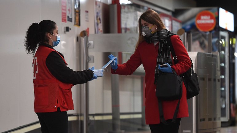 Uma voluntária da Cruz Vermelha distribui máscaras num dos acessos da estação de Chamartín, em Madrid