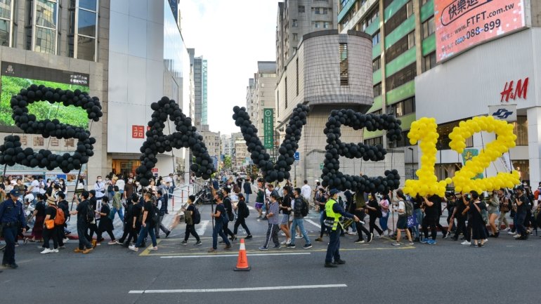 As centenas de pessoas que se manifestaram em Taipé estavam vestidas de preto e a usar máscaras faciais, enquanto gritavam &quot;Glória a Hong Kong&quot;.