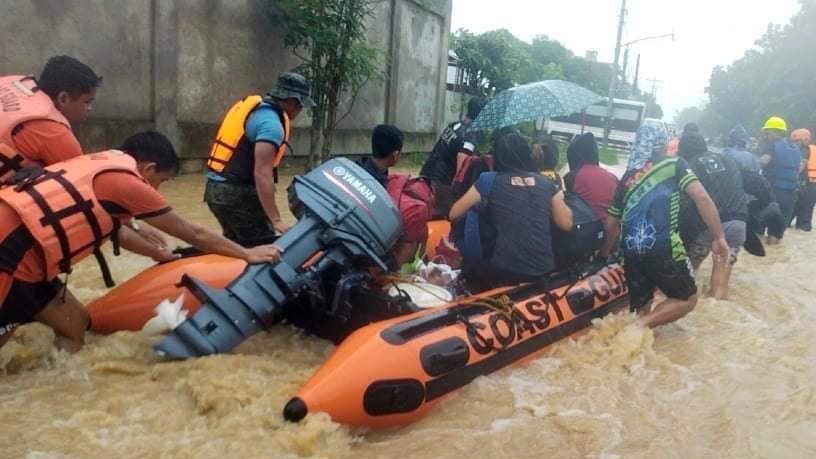 epa09885401 A handout photo made available by the Philippine Coast Guard (PCG) shows rescuers assist villagers in a rubber boat on a flooded village in Panitan, Capiz province, Panay island, Philippines, 12 April 2022. According to local authorities reports, scores of villagers were burried from landslides in the central and southern Philippines brought by Typhoon Megi.  EPA/PCG / HANDOUT BEST QUALITY AVAILABLE HANDOUT EDITORIAL USE ONLY/NO SALES