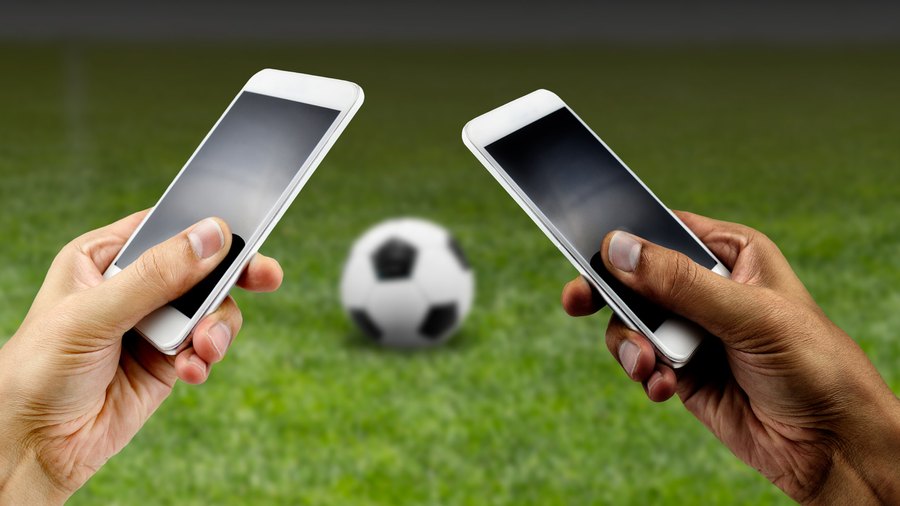 Uma bola de futebol e um smartphone um aplicativo de apostas para anunciar  jogos de futebol e casa de apostas